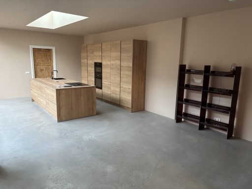 Airless Spuiten van wanden en plafond Moderne keuken met houten kasten en een betonnen vloer, ruime indeling.