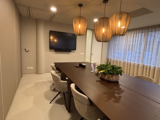 Schilder & behangwerk Abin accountants Moderne vergaderzaal met een lange tafel, stoelen, planten en hanglampen.